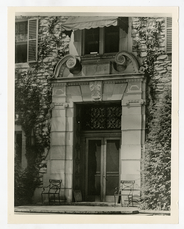 Ivy-covered entrance of Graylyn Estate mansion with chairs
