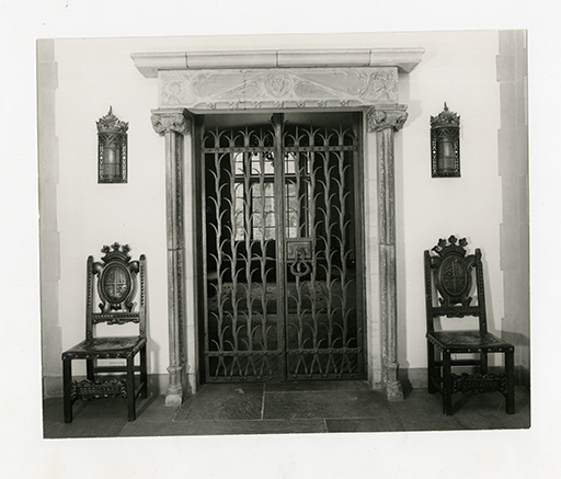 Ornate Iron Gate with Carved Stone Surround and Chairs