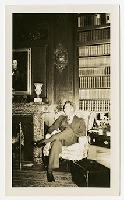 Generated thumbnail: Seated Man in a Study with Fireplace and Bookshelves