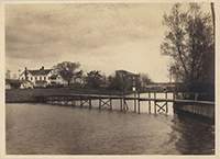 Generated thumbnail: Footbridge over water. Two houses in background.
