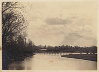 Generated thumbnail: Footbridge over water. Large building on hill in background.